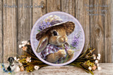 A round decorative plate featuring a rabbit wearing a hat and surrounded by flowers and greenery.