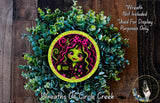 A wreath made of green plants and featuring a cartoon character with a green and pink color scheme.
