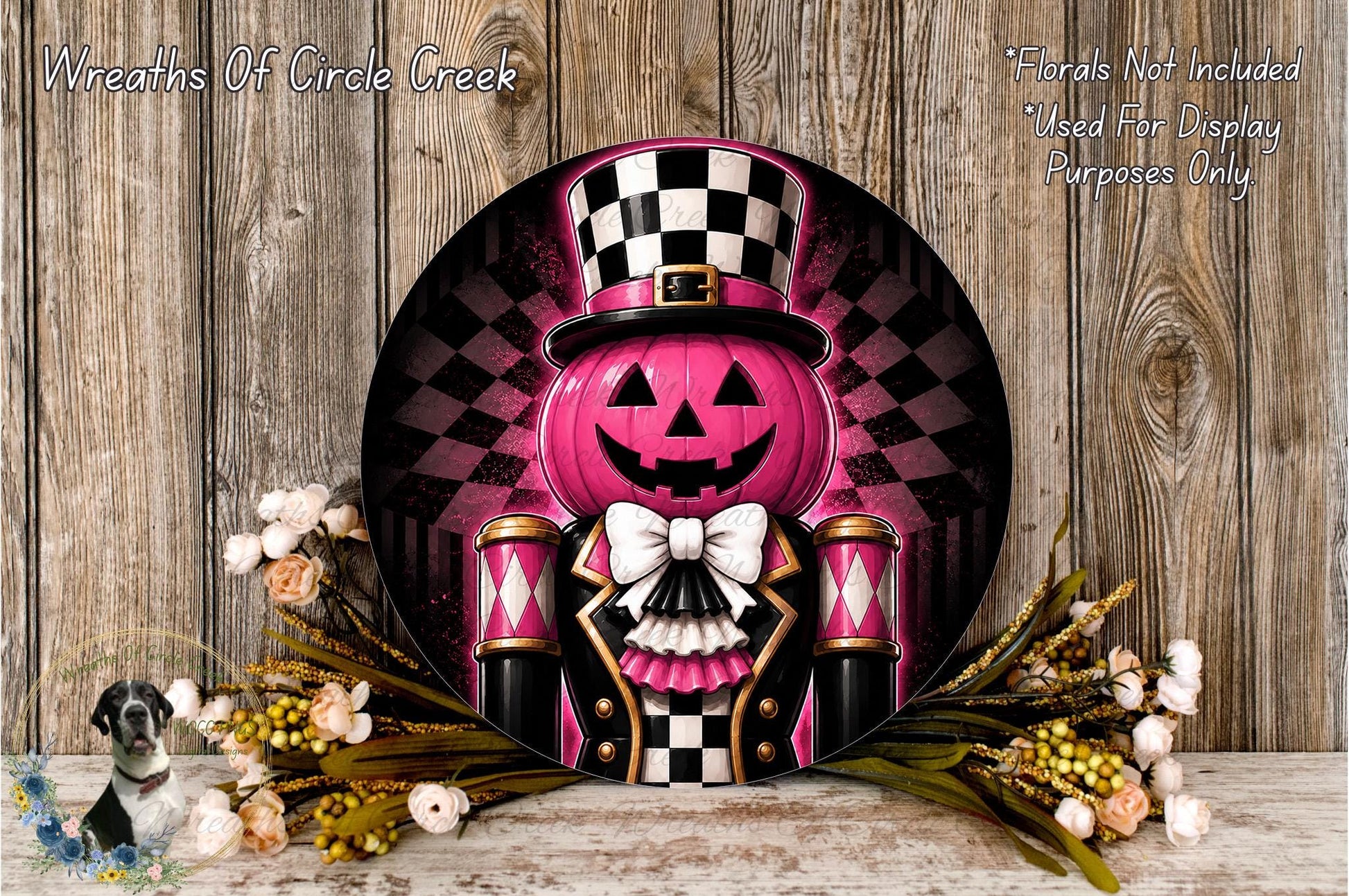 a Halloween-themed wreath with a pumpkin and a nutcracker-like character wearing a top hat and bowtie. The wreath is displayed on a wooden surface, surrounded by flowers.
