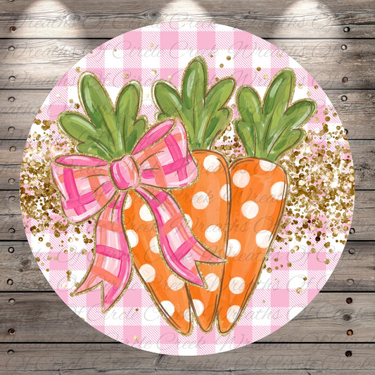 A circular decorative piece featuring three orange carrots with green leaves, each adorned with a pink bow, set against a pink and white checkered background with gold glitter accents.