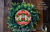A festive Christmas wreath made of evergreen branches and a red and white circular sign with the text "MERRY CHRISTMAS" in the center.