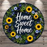 A wreath made of various flowers, including sunflowers, daisies, and other colorful blooms, surrounding the text "Home Sweet Home" in a circular arrangement.