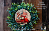 a wreath with a red truck and flowers, surrounded by greenery. The wreath is displayed on a wooden surface, and there is a text overlay that reads "Welcome Wreath Not Included * Used For Display Purposes Only" and "Wreaths of Circle Creek".