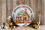 A festive Christmas wreath with a gingerbread house and a gingerbread man, surrounded by flowers and greenery, with the text "Merry Christmas" displayed on the wreath.