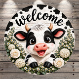 A black and white cow with horns is surrounded by white flowers and greenery, with the word "welcome" written above it.
