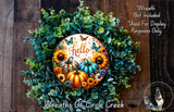 A wreath made of various autumn-themed elements, including sunflowers, pumpkins, and greenery, with a decorative plate featuring the word "Hello" in the center.