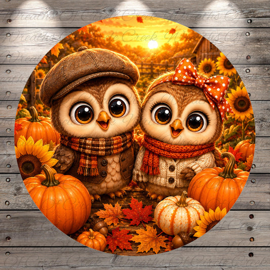 A pair of cartoon owls, one wearing a hat and scarf and the other with a bow, are surrounded by pumpkins, sunflowers, and autumn leaves in a vibrant fall scene.