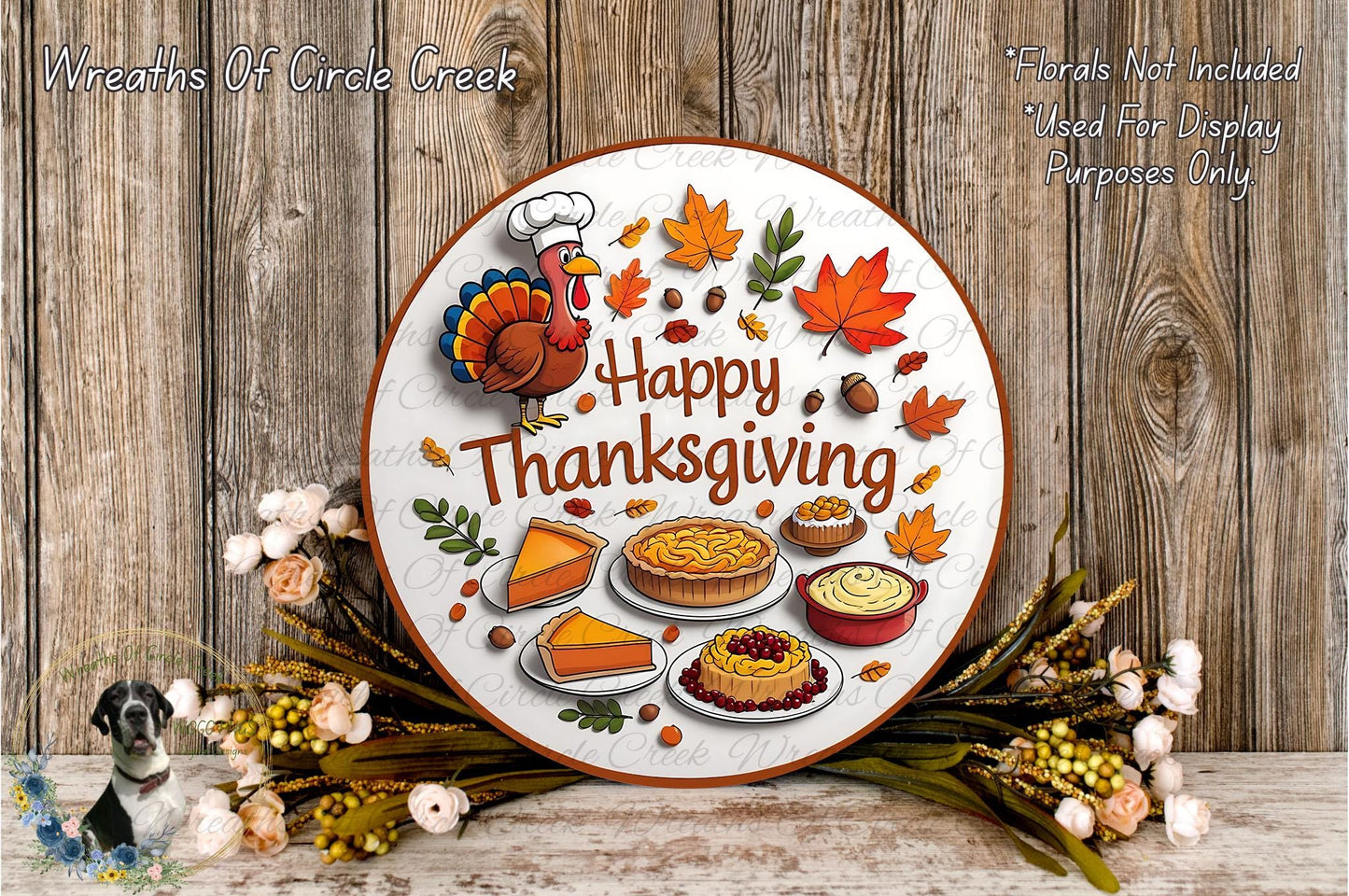 A Thanksgiving-themed wreath with a turkey, autumn leaves, pies, and other fall-themed items, surrounded by flowers and placed on a wooden surface.