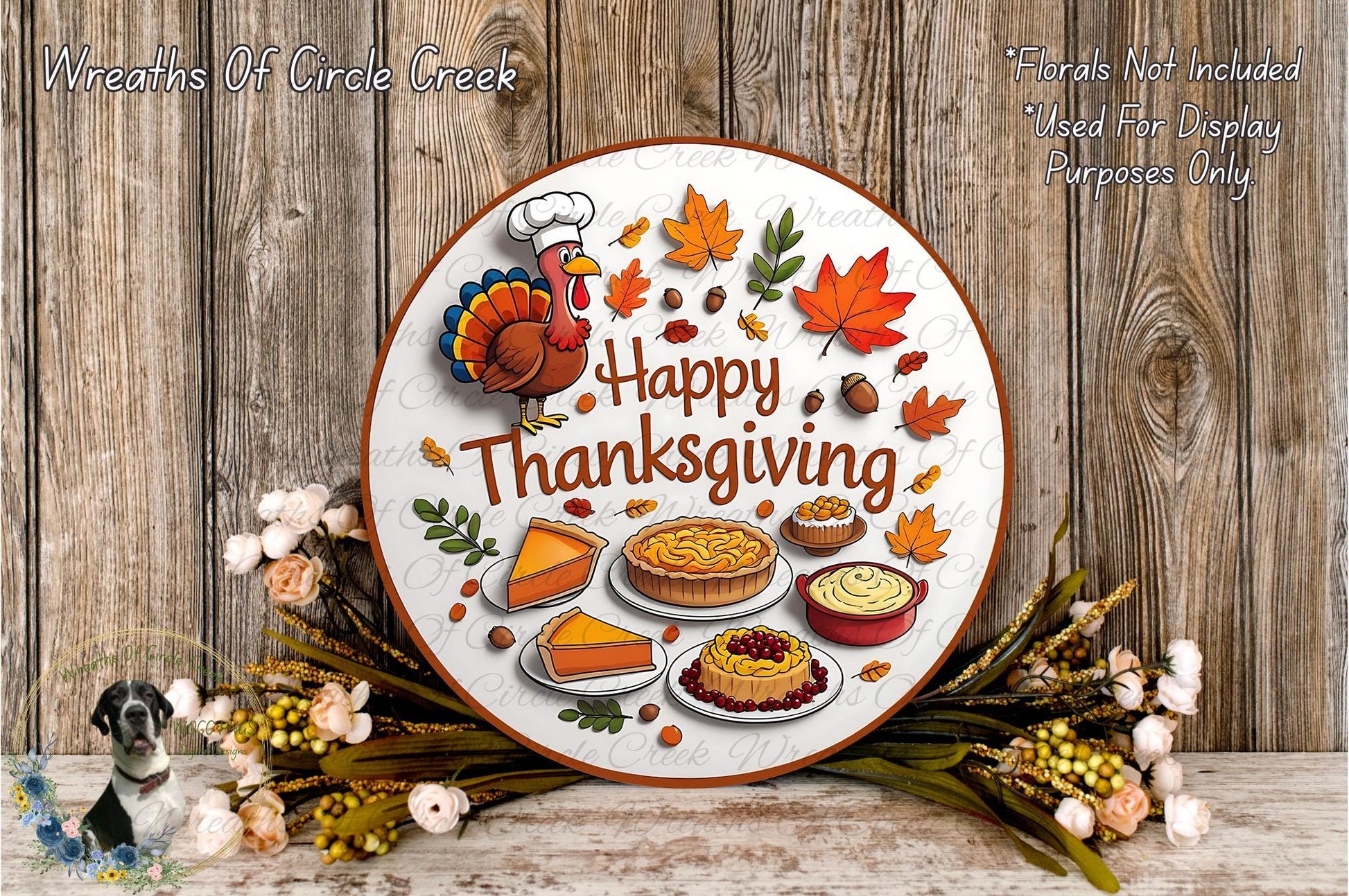 A Thanksgiving-themed wreath with a turkey, autumn leaves, pies, and other fall-themed items, surrounded by flowers and placed on a wooden surface.