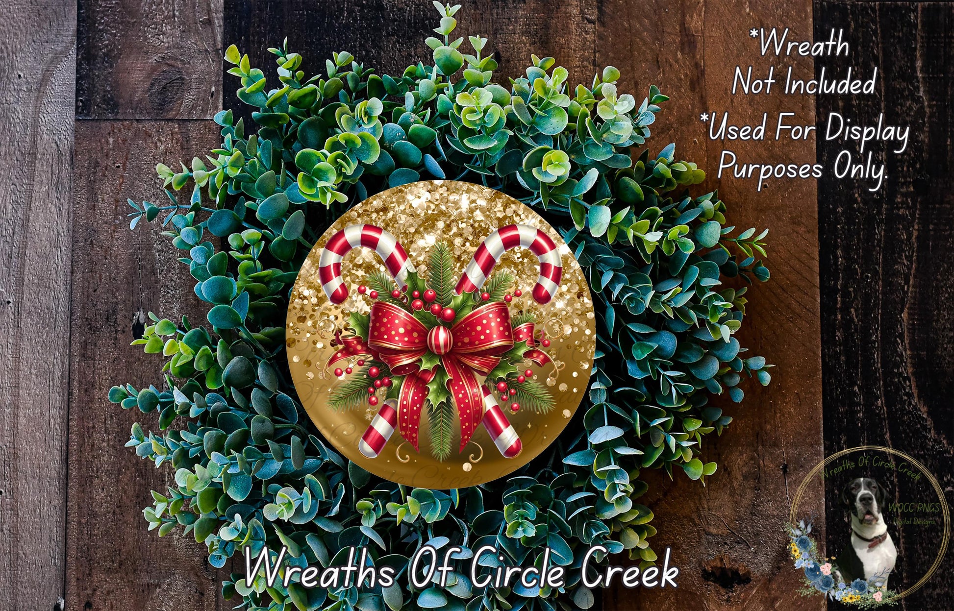 A wreath made of green leaves and red and white candy canes, with a gold bow at the center, is displayed on a wooden surface.