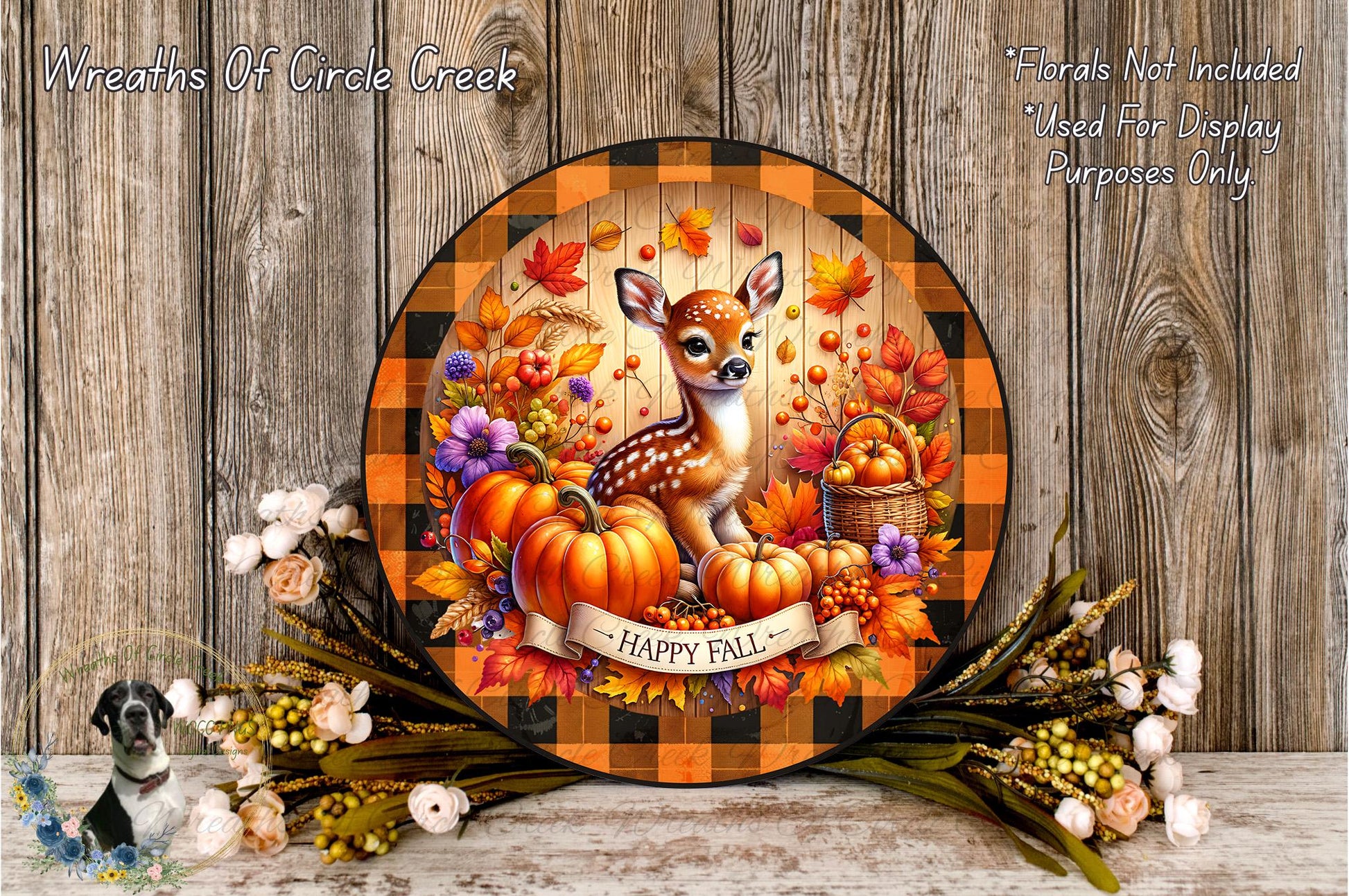 A decorative plate featuring a deer surrounded by autumn foliage, pumpkins, and flowers, with the text "Happy Fall" displayed. The plate is placed on a wooden surface, and there are additional fall-themed decorations in the background.