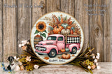 A round wooden plaque with a pink vintage truck and a floral arrangement, including pumpkins, sunflowers, and fall foliage, set against a wooden background.