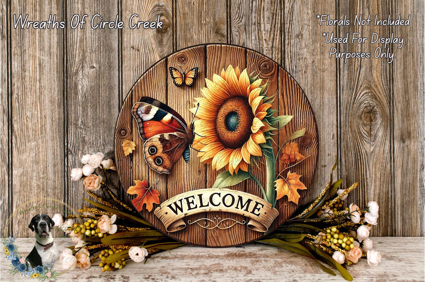 a wooden sign with a sunflower and butterfly design, surrounded by autumn leaves and flowers, with the word "WELCOME" displayed on the sign.