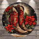 A pair of red cowboy boots with decorative details, surrounded by red poinsettia flowers and greenery, set against a wooden background with stars.