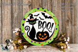 A Halloween-themed wreath with a black cat, a jack-o-lantern, and bats, surrounded by flowers and a wooden background.