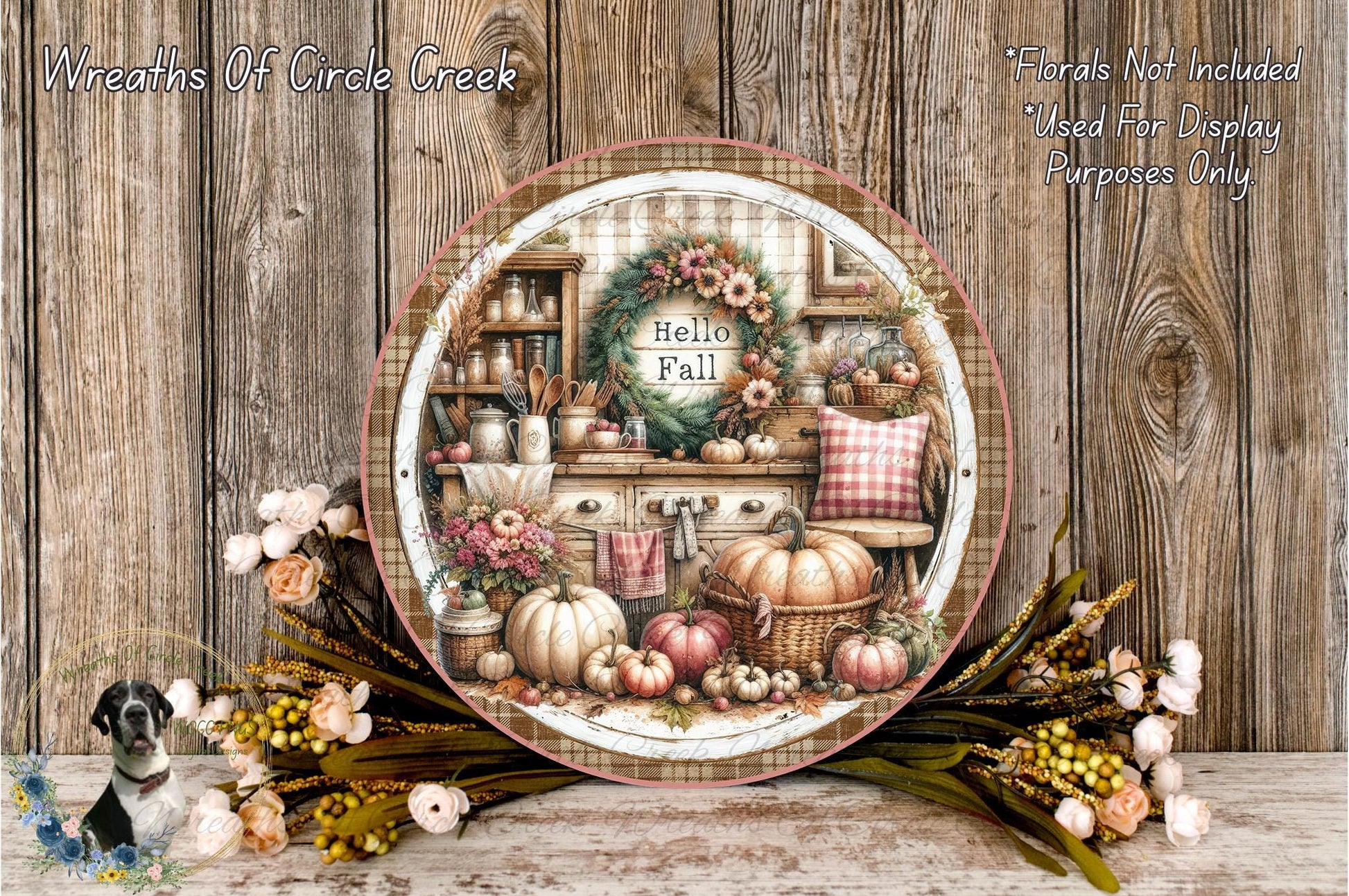 a decorative plate with a wreath and fall-themed items, such as pumpkins, flowers, and a kitchen scene, displayed on a wooden surface.