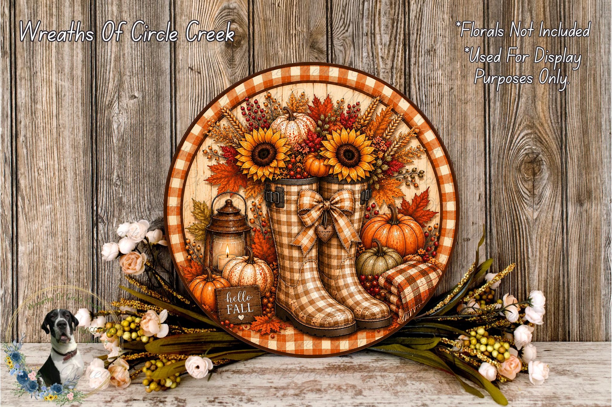A decorative wreath made of autumn-themed elements, including sunflowers, pumpkins, and plaid boots, is displayed on a wooden surface.
