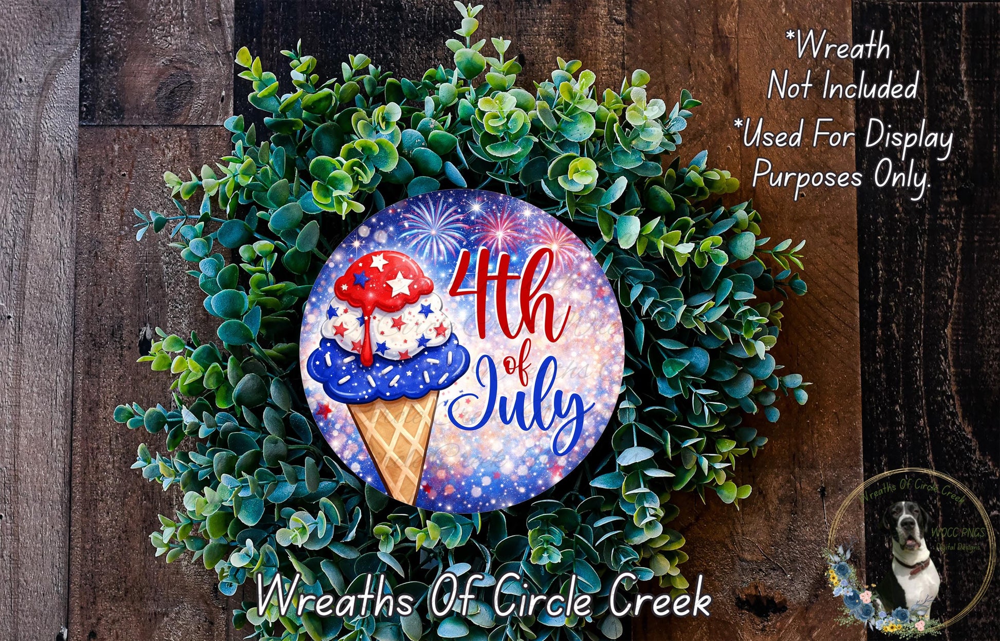 A wreath made of green leaves and featuring a colorful design with a red, white, and blue ice cream cone and fireworks. The wreath is displayed on a wooden surface, and there is a text overlay that reads "Wreath Not Included * Used For Display Purposes Only".