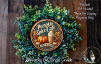 a wreath made of various fall-themed elements, including a pumpkin, leaves, and a coffee mug, with the text "Pumpkin Spice Cafe" and "Best in Town" displayed on it.
