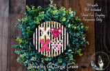 A wreath made of green leaves and flowers, with a decorative design featuring the letters 'XO' and hearts.