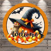 A round sign with a witch's hat, a pumpkin, and candy corn, along with the word "Welcome" written on it.