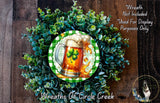 A wreath made of green and white leaves, with a beer mug featuring a shamrock design in the center.