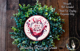 a wreath made of green foliage and a wine glass with a red liquid inside, surrounded by text that reads "Sips about to go down" and "Wreath Not Included Used For Display Purposes Only".