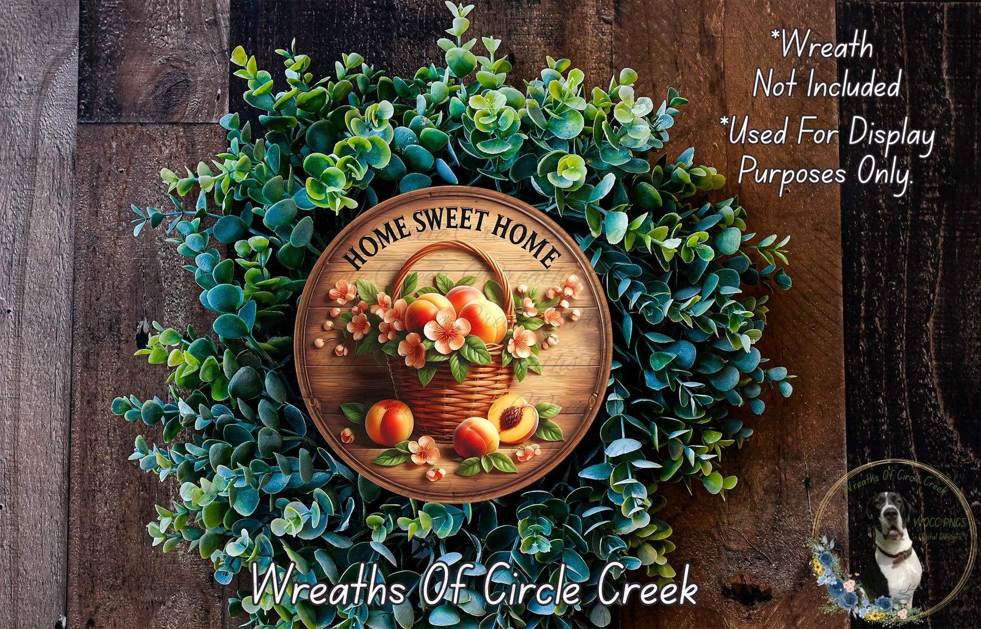 a wreath made of various green plants and flowers, with a wooden sign that reads "Home Sweet Home" in the center. The wreath is displayed on a wooden surface, and there is a small dog in the bottom right corner of the image.