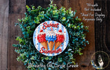 a wreath made of green leaves and topped with three colorful ice cream cones, each with a different flavor. The wreath is displayed on a wooden surface, and there is a small dog in the bottom right corner of the image.