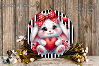 A round, decorative wreath featuring a white bunny with a red bow and heart-shaped decorations, surrounded by flowers and greenery.