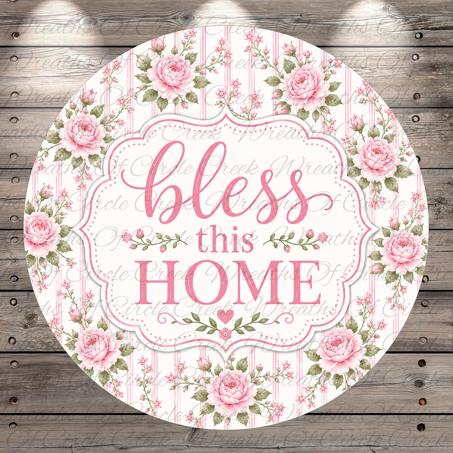 A round floral sign with the text "bless this home" in a decorative font, surrounded by pink roses and greenery.