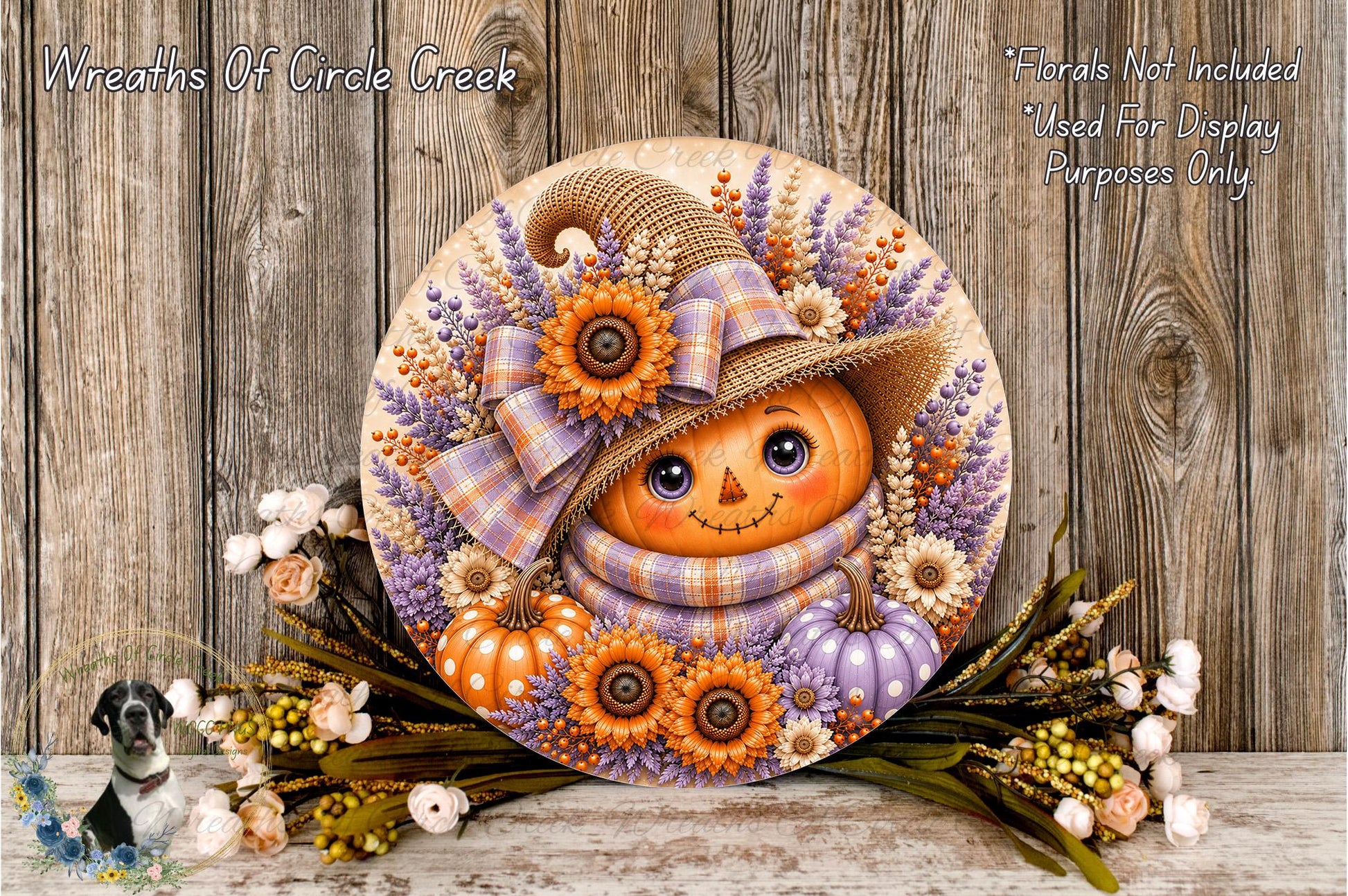 A decorative wreath featuring a pumpkin face, flowers, and a plaid hat, placed on a wooden surface.