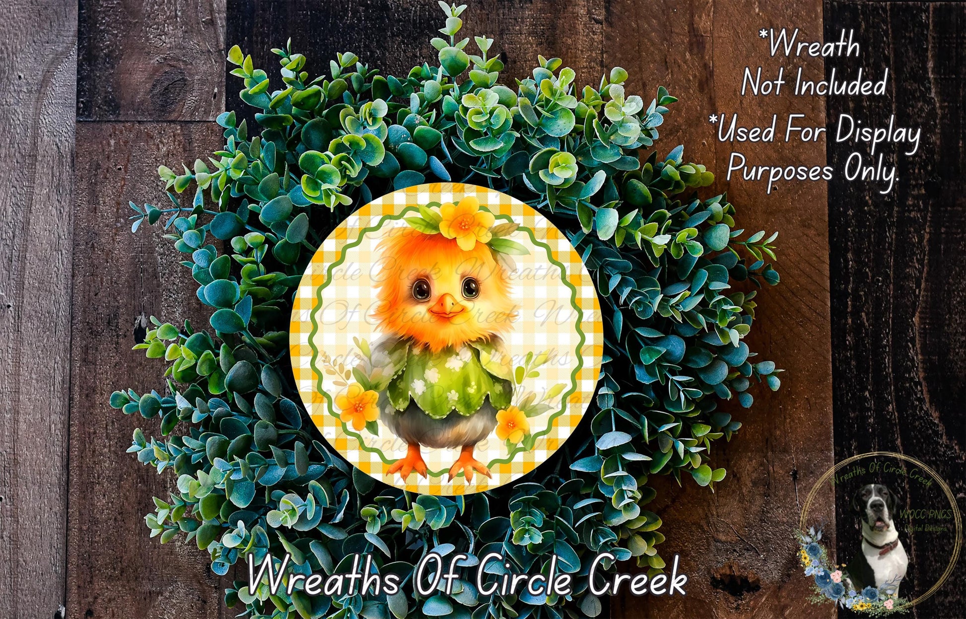 a wreath with a small, orange chicken as the central decoration, surrounded by a lush, green plant. The wreath is displayed on a wooden surface, and there is a small dog visible in the bottom right corner of the image.
