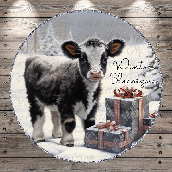 A black and white cow stands in front of a snowy landscape, with a gift box and a "Winter Blessings" sign in the background.