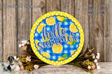 a round sign with the text "Hello Summer" on it, surrounded by flowers and placed on a wooden surface.
