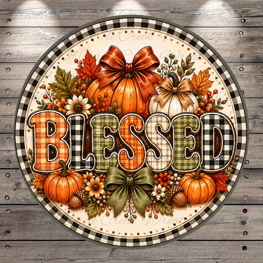 A decorative sign with the word "Blessed" written on it, surrounded by various fall-themed elements such as pumpkins, leaves, and a bow.