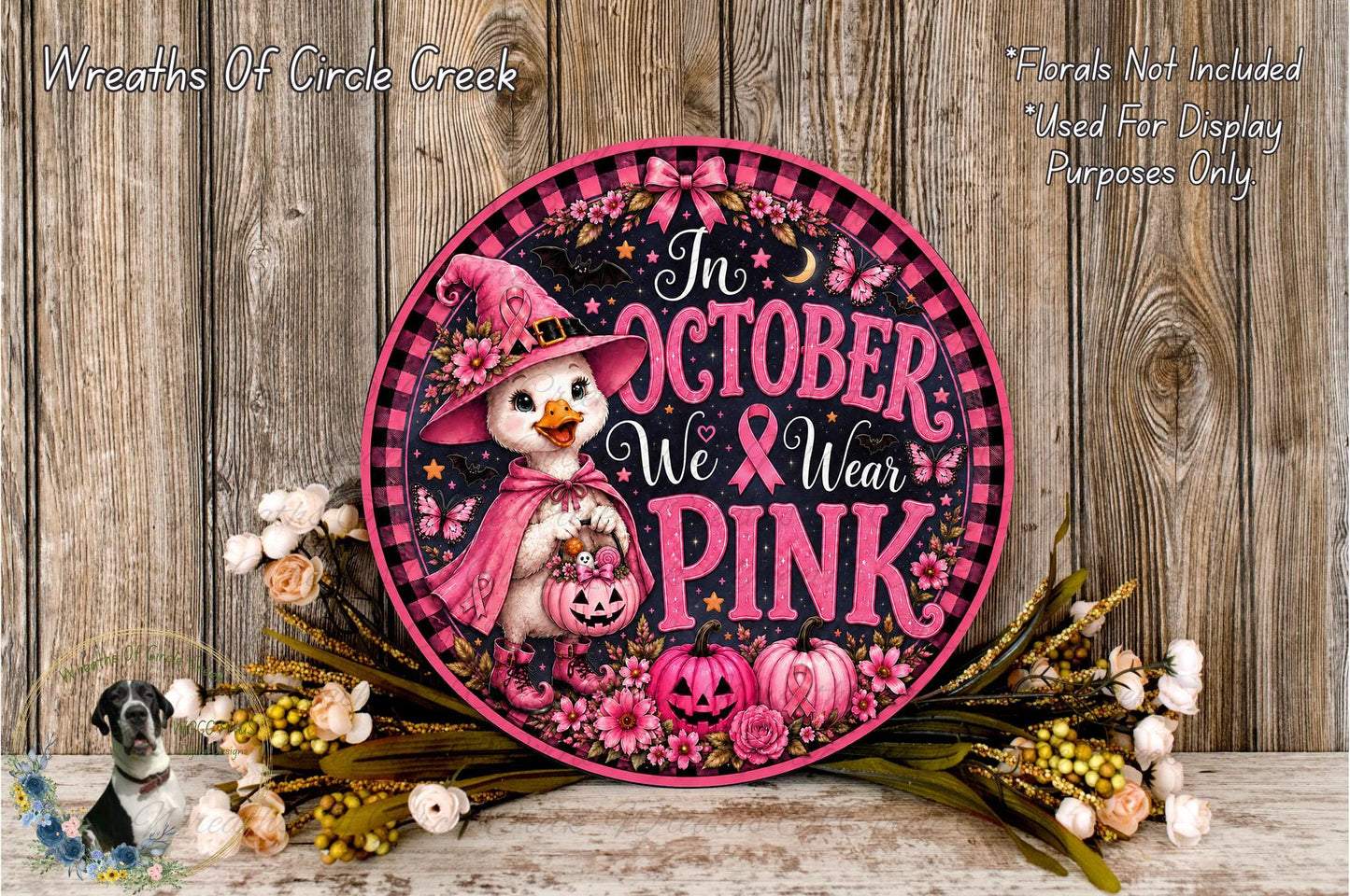 A decorative sign with a cartoon duck wearing a witch's hat and holding a pumpkin, surrounded by flowers and a wooden background.