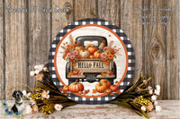 a decorative round sign with a truck and fall-themed elements, such as pumpkins and flowers, placed on a wooden surface.