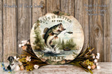 a round sign with a fish jumping out of the water, surrounded by flowers and a wooden background.