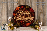 A circular sign with the text "Happy Thanksgiving" surrounded by autumn leaves and flowers, placed on a wooden surface.