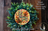 a wreath made of various fall-themed elements, including pine cones, leaves, and flowers, displayed on a wooden surface.