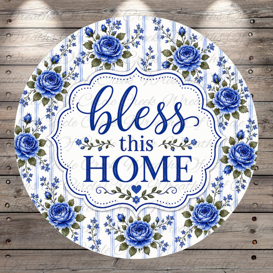 A round sign with a floral border and the text "bless this home" in blue and white.