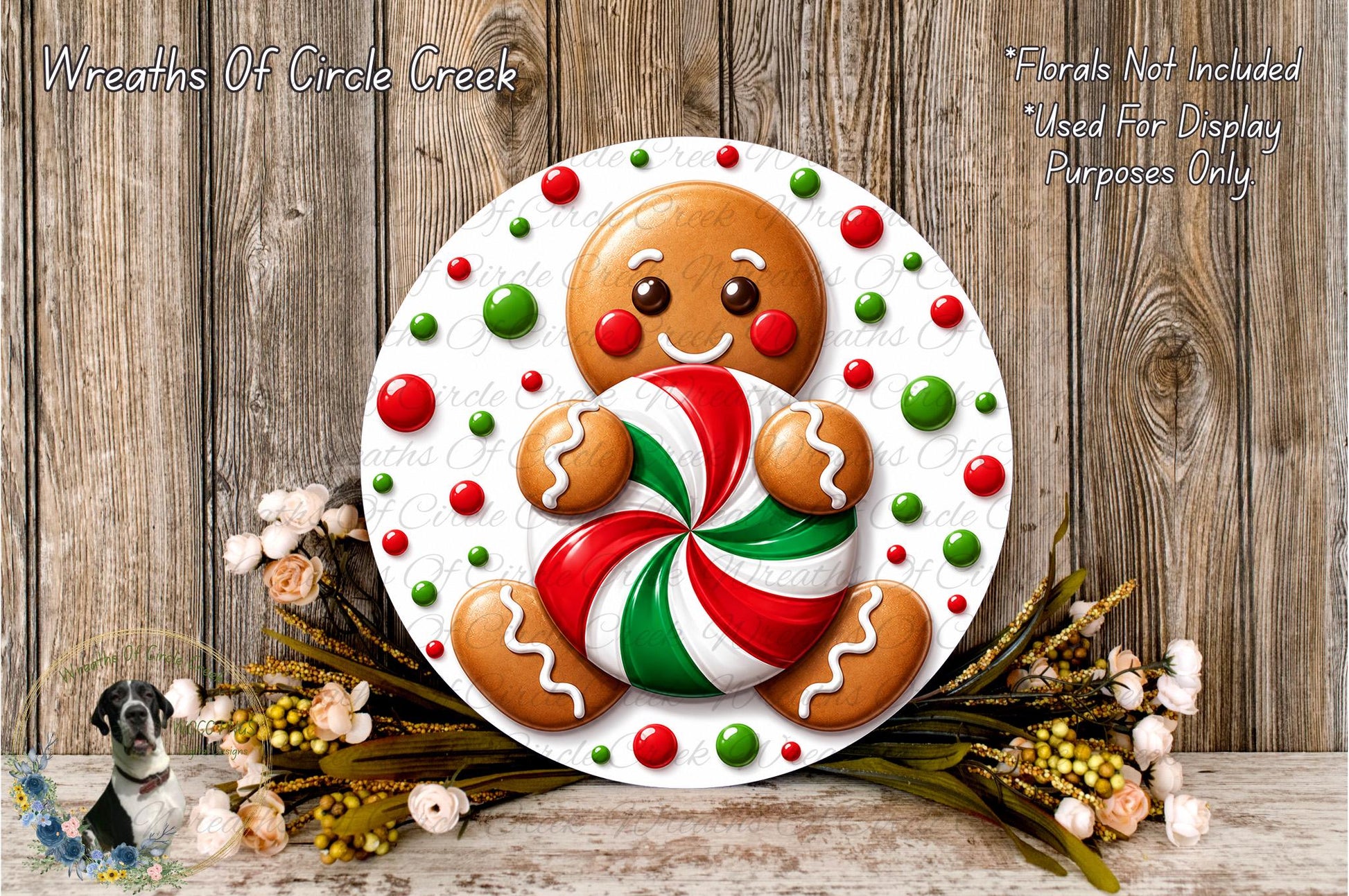A gingerbread man figure holding a candy cane is displayed on a white plate, surrounded by a wreath of flowers and greenery against a wooden background.