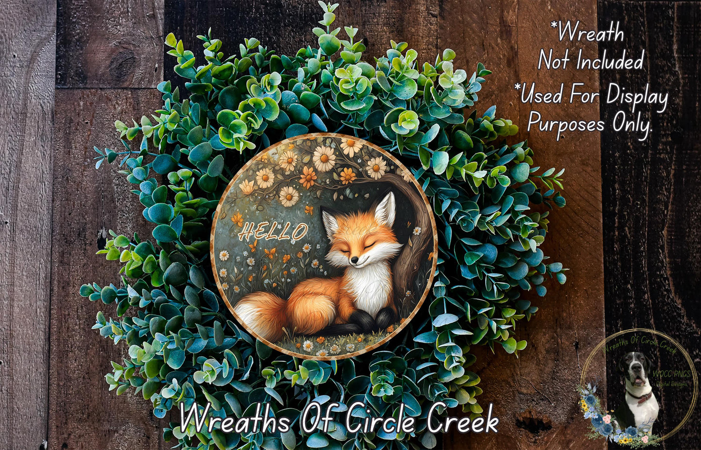 A wreath made of green plants and flowers, with a fox sleeping in the center. The fox is surrounded by the greenery, and the word "Hello" is written on the wreath.