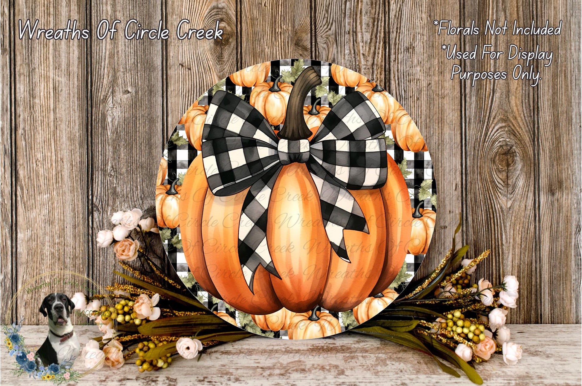 a decorative pumpkin wreath with a black and white checkered bow, placed on a wooden surface. The wreath is surrounded by a variety of fall-themed flowers, creating a festive and seasonal display.