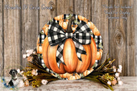 a decorative pumpkin wreath with a black and white checkered bow, placed on a wooden surface. The wreath is surrounded by a variety of fall-themed flowers, creating a festive and seasonal display.